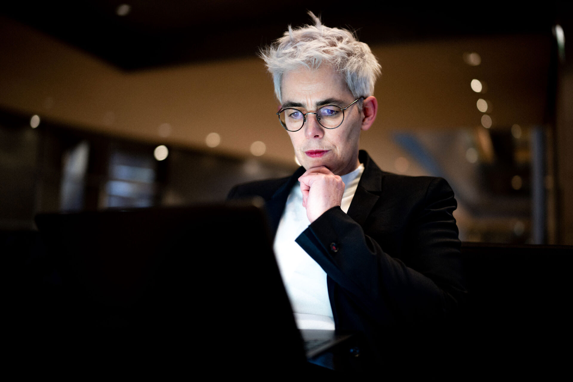 Ulle Schauws sitzt vor einem Laptop und stützt das Kinn mit der Hand